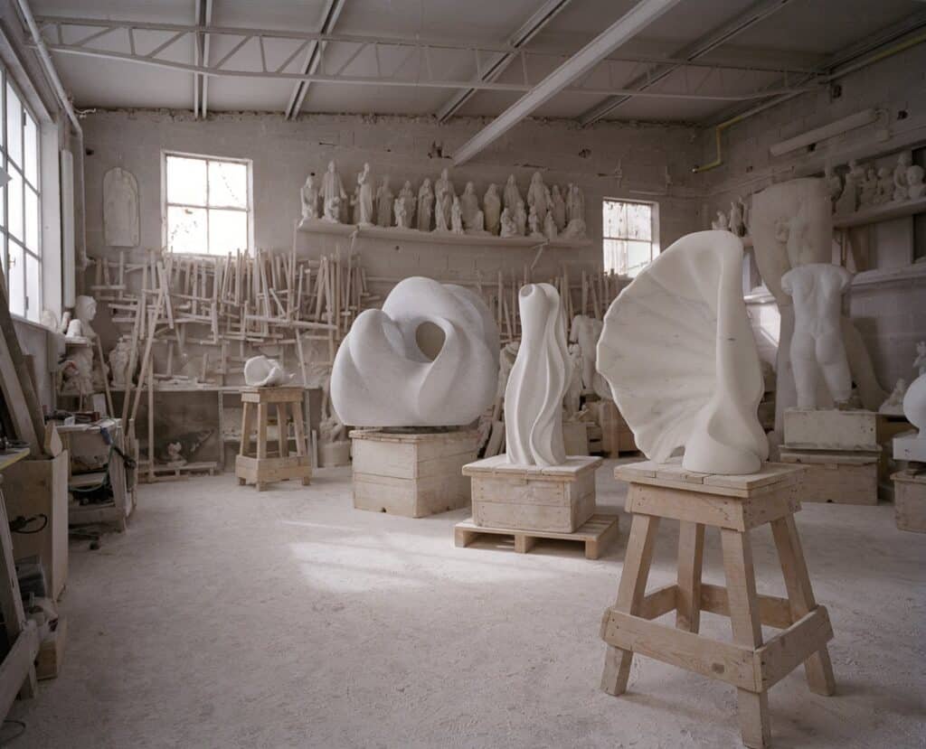 laboratorio artistico con sculture in lavorazione, ambientazione artigianale realistica