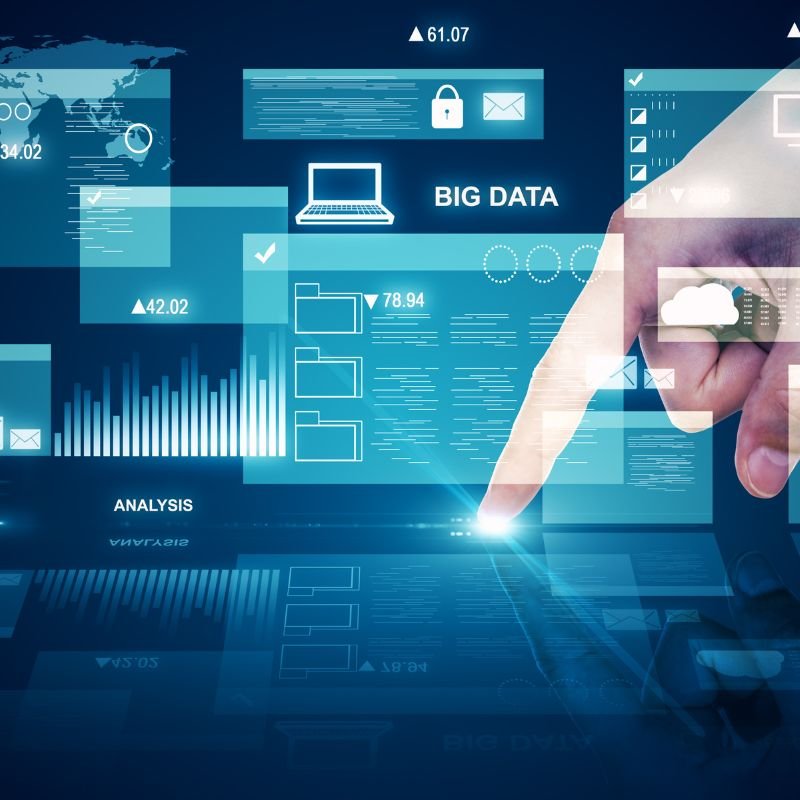 Mano che interagisce con interfaccia virtuale contenente grafici, dati e simboli digitali relativi a big data e analisi.